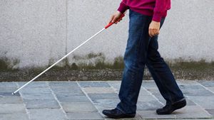 Blind man using walking cane