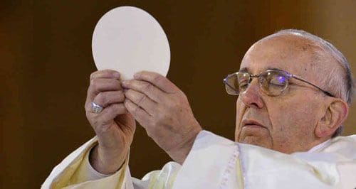 Pope Francis holding the Sacred Host aloft