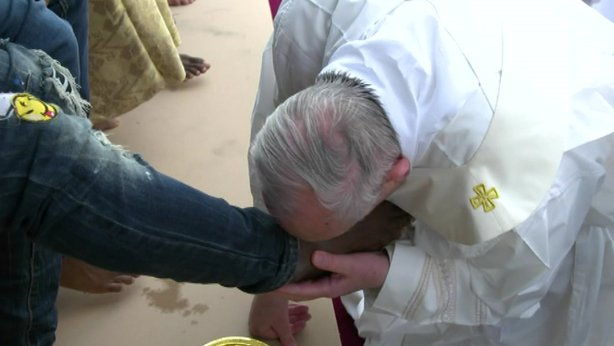 Pope Francis kisses the feet of a lay-person on Holy Thursday