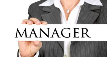 Woman holding a sign titled Manager.