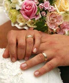 Couple holding hands and displaying their wedding rings