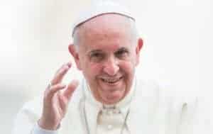 Pope Francis smiling and waving.