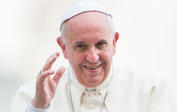 Pope Francis smiling and waving.