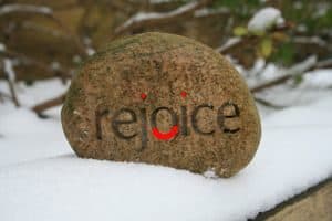 Stone with the word "Rejoice"