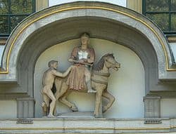 Stone statue of St Martin de Tours on horseback sharing his cloak with a poor beggar.