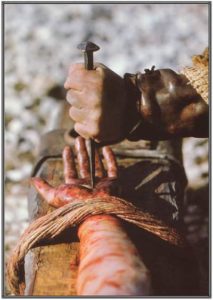 A nail being driven through Jesus' hand