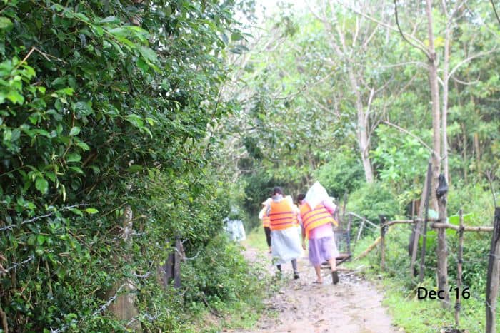 Volunteers carrying food parcels from riverboats to homes